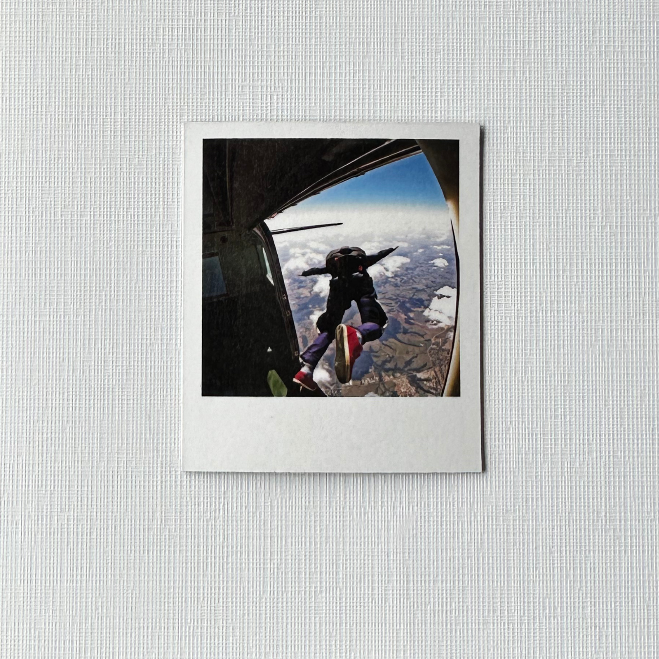 Framed photo of a person skydiving with a view of the Earth from an airplane window. 6 pack polaroid custom photo magnets. 