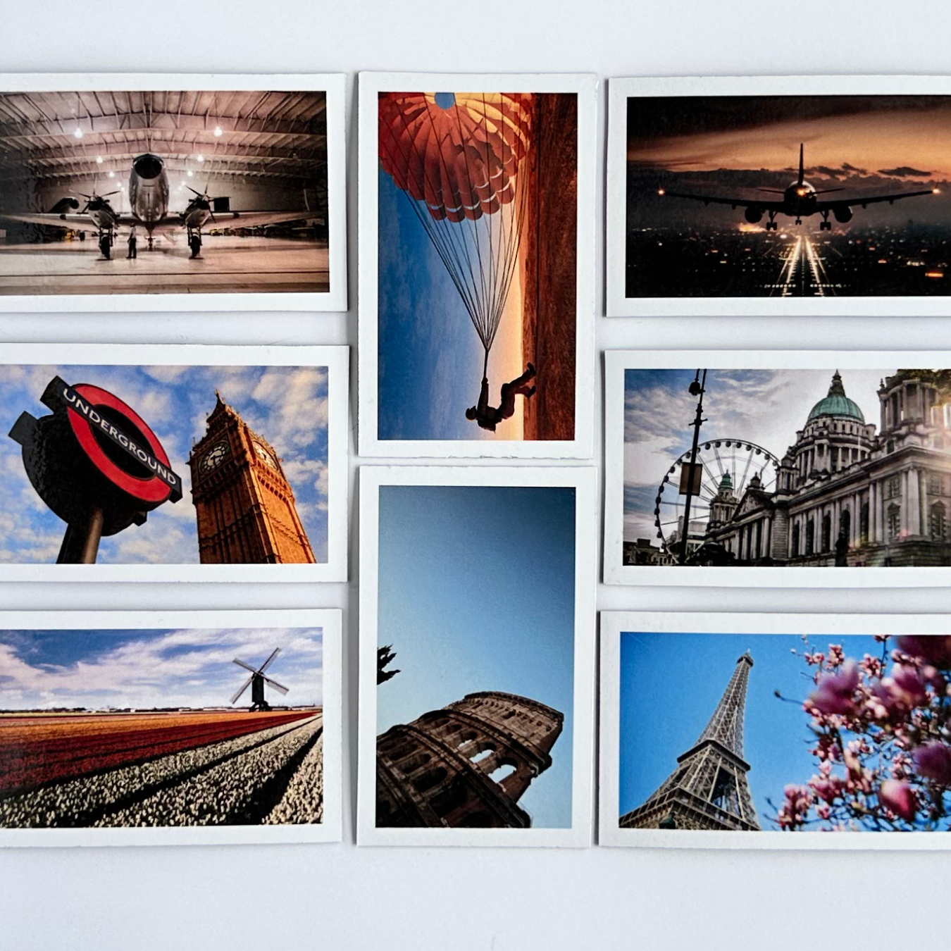 Collage of various travel-themed magnetic photographs on a white wall.